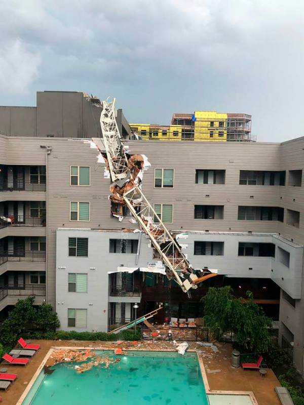 This photo taken and provided by Michael Santana shows a construction crane toppling on an apar ...