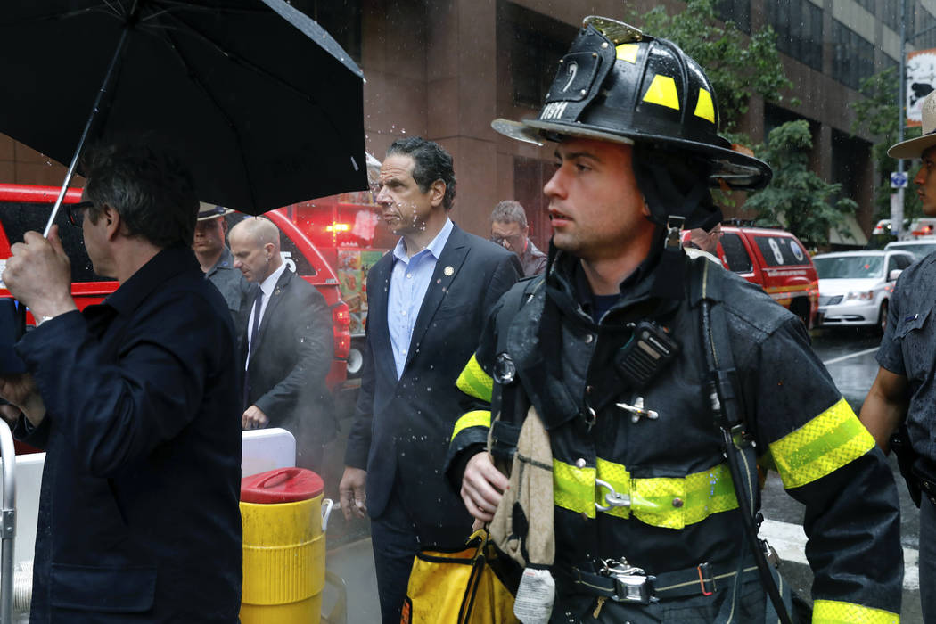 New York Gov. Andrew Cuomo, center, and first responder personnel walk near the scene where a h ...