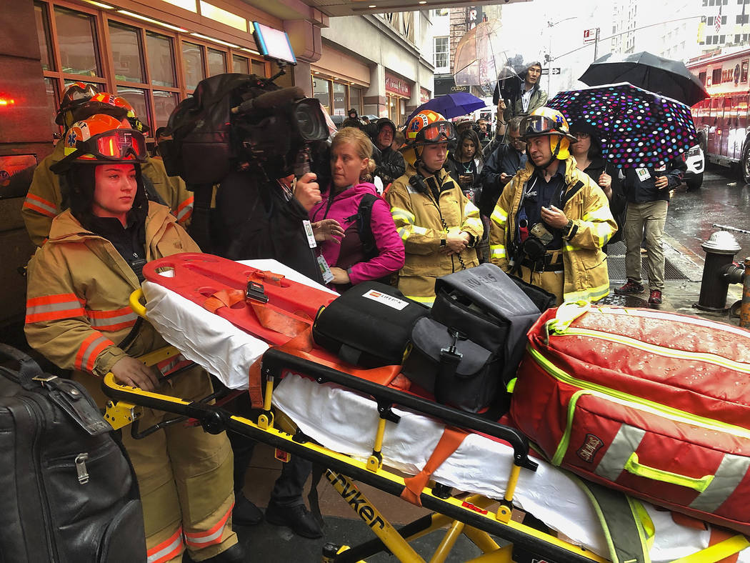 Firefighters prepare to bring a stretcher into a building, Monday, June 10, 2019, in New York, ...