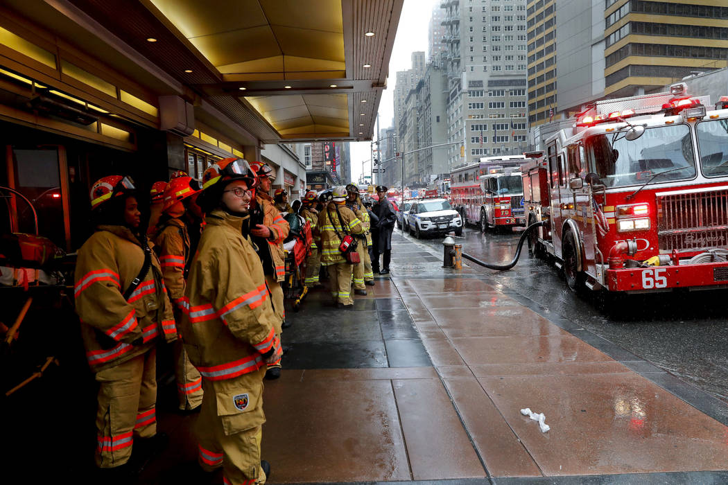 Firefighters respond to the scene where a helicopter crash-landed on the roof of a midtown Manh ...