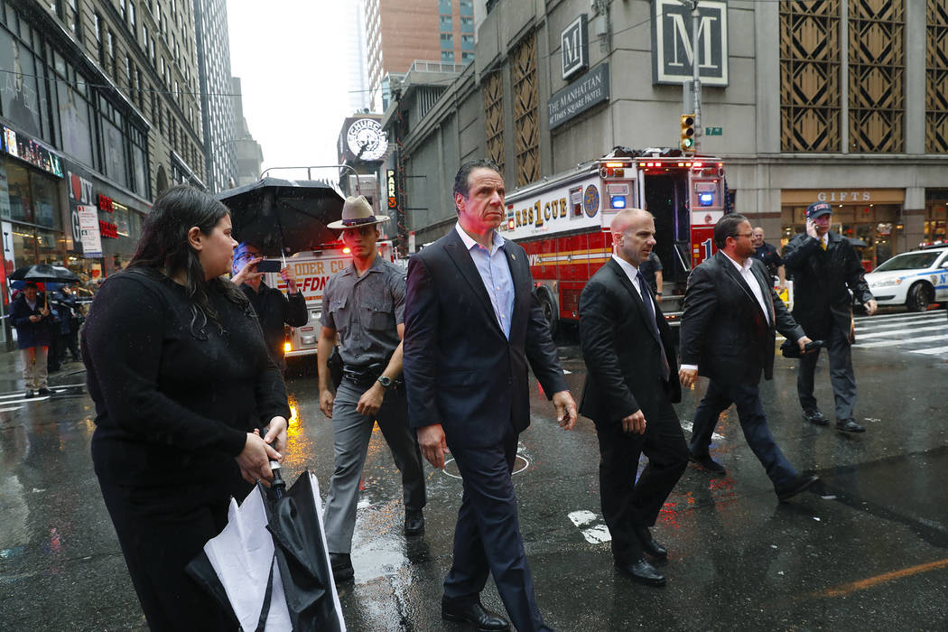 New York Gov. Andrew Cuomo, center, walks near the scene where a helicopter was reported to hav ...