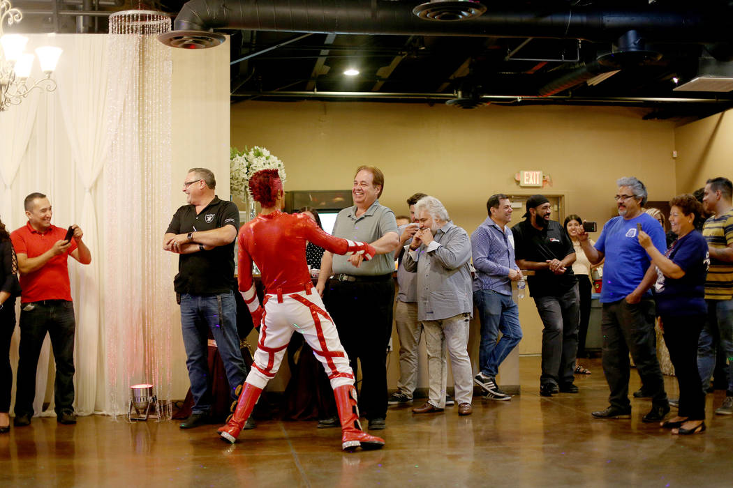 Jimmy Gonzales, a mannequin dancer, encourages Doug Rankin in the crowd at the election night v ...