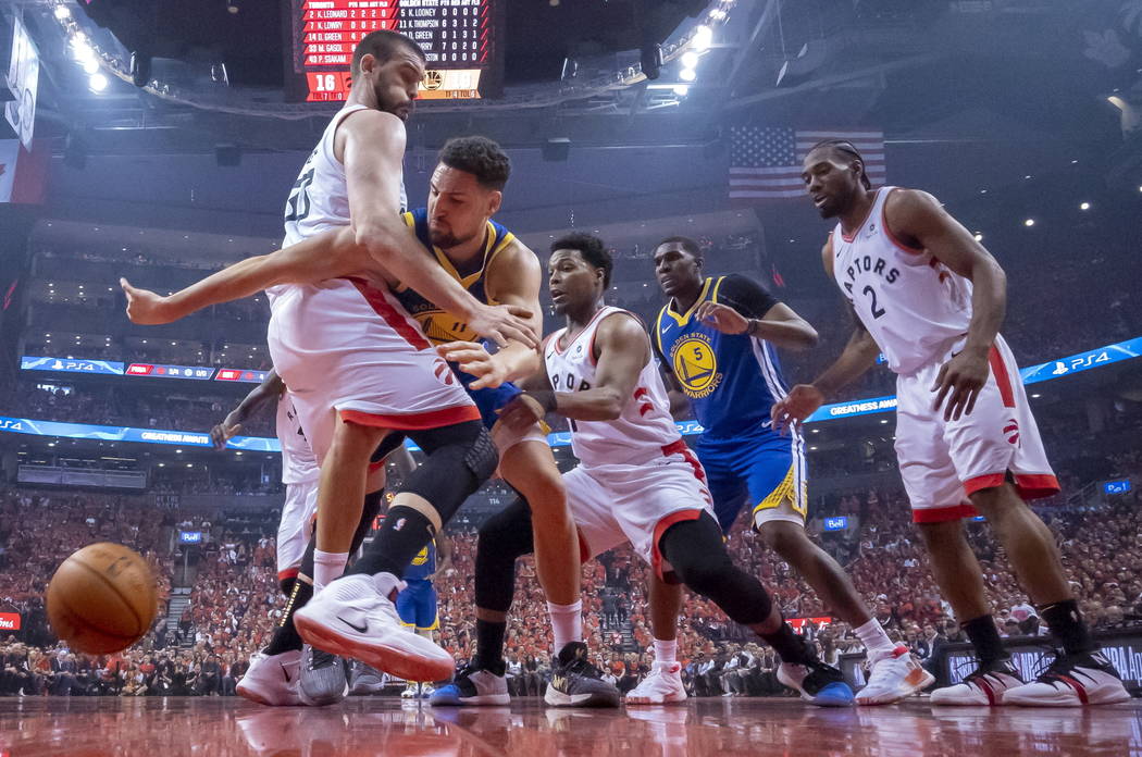 Golden State Warriors guard Klay Thompson (11) reaches for the ball past Toronto Raptors' Marc ...