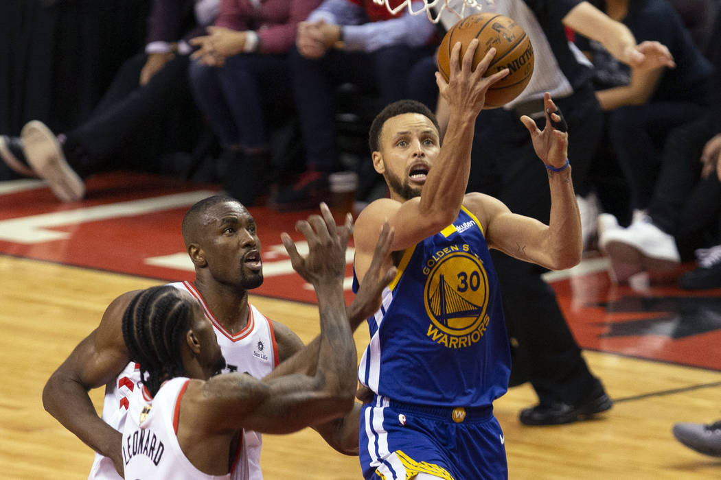 Golden State Warriors guard Stephen Curry (30) drives pass Toronto Raptors center Serge Ibaka ( ...