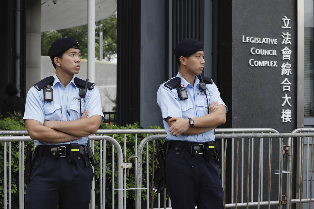 Police stand guard at fencing surrounding the Legislative Council to help block protesters duri ...