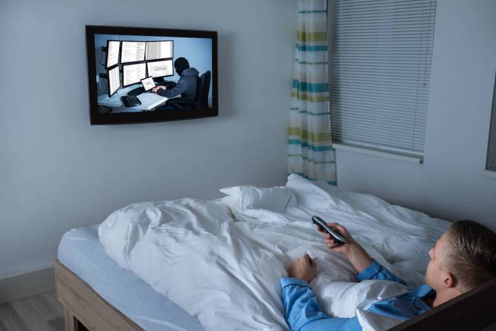 A man watches television in bed. (Getty Images)