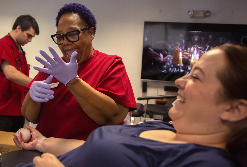 Barbara Moor, 57, left, prepares to draw blood from Audra Findley, right, during the American R ...