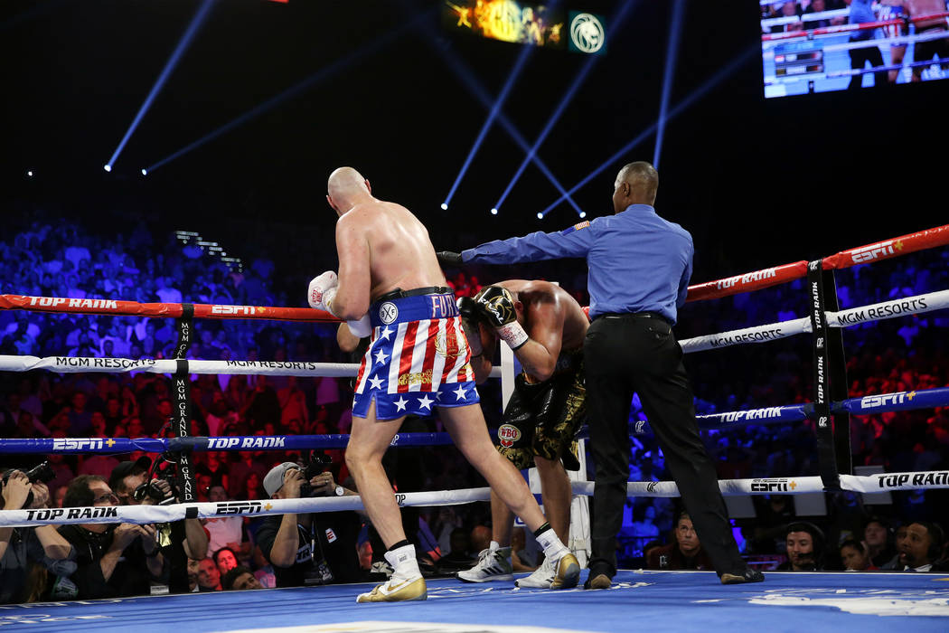 Referee Kenny Bayless, right, steps in to stop the fight between Tyson Fury, left, and Tom Schw ...