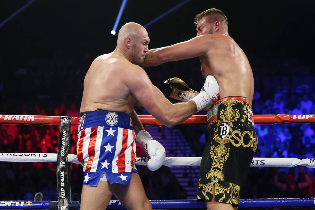 Tyson Fury, left, connects a punch against Tom Schwarz in the second round of the lineal heavyw ...