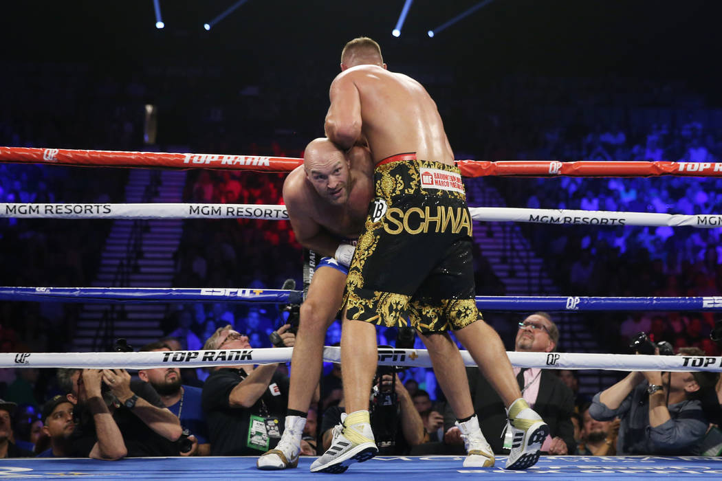 Tyson Fury, left, defends against Tom Schwarz in the second round of the lineal heavyweight bou ...
