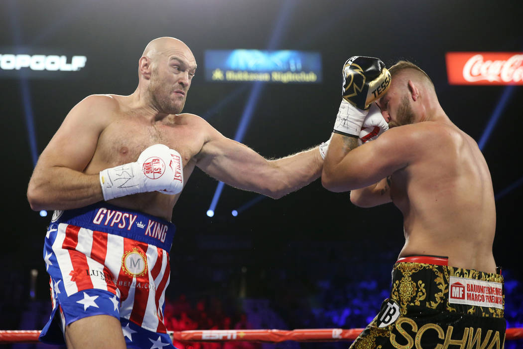 Tyson Fury, left, connects a punch against Tom Schwarz in the first round of the lineal heavywe ...