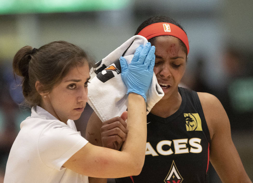 Las Vegas Aces' Sydney Colson, right, is led off the court after being injured in the first qua ...