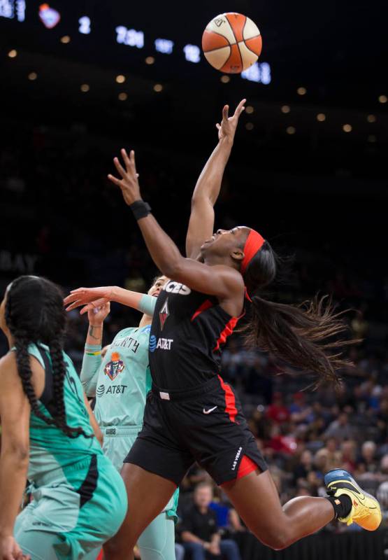 Las Vegas Aces guard Jackie Young (0) drives past New York Liberty guard Brittany Boyd (15) in ...