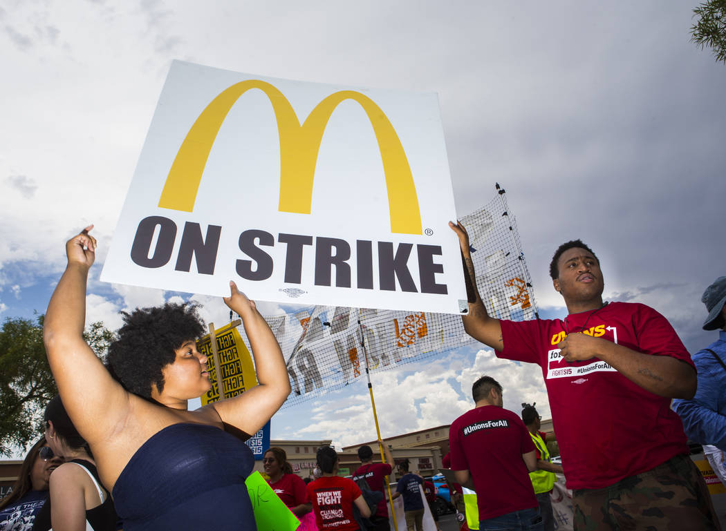 Tavosha Clemons, left, and Kentrell Young, both of Las Vegas, hold up a sign while protesting i ...