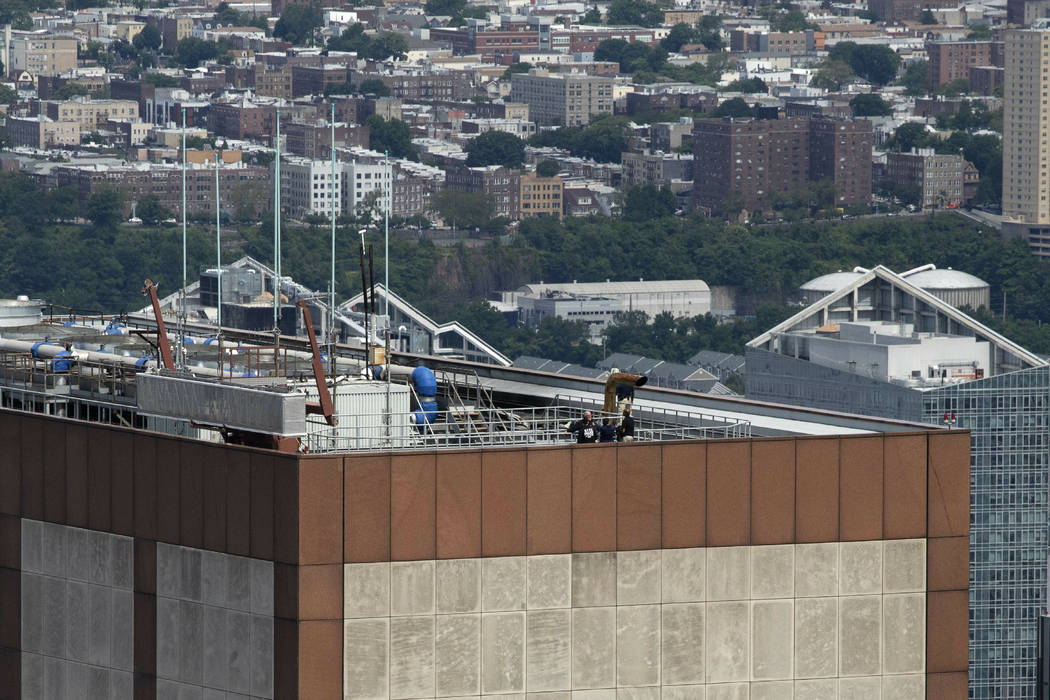 Law enforcement personnel work on the roof of the AXA Equitable building, Tuesday, June 11, 201 ...