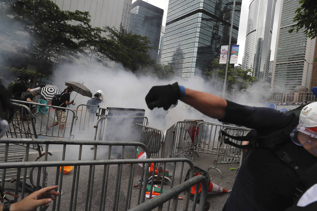 Protesters react to tear gas during a massive protest near the Legislative Council in Hong Kong ...