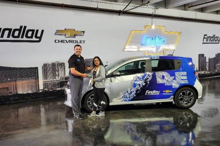 Findlay Chevrolet General Manager Doug Fleming congratulates Clark High School graduate Angela ...