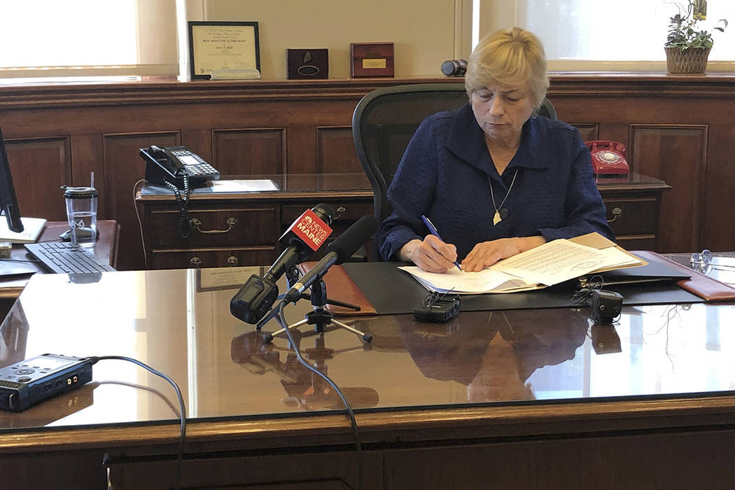 Maine Democratic Gov. Janet Mills signs a bill Wednesday, June 12, 2019, in her office in Augus ...