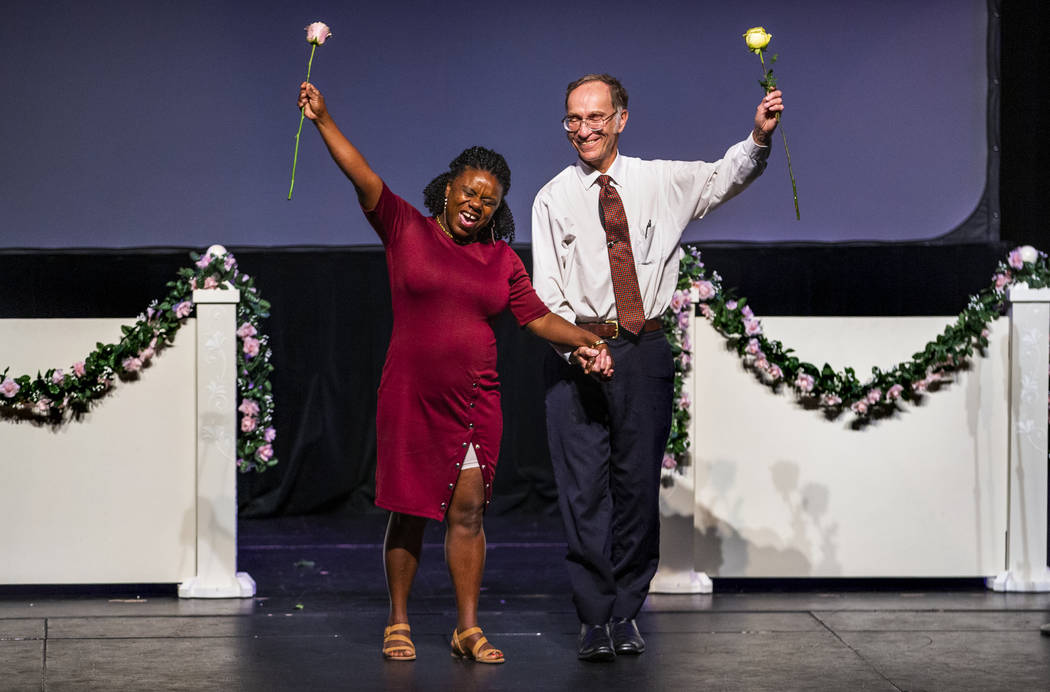 Sherene Facey and William Archbold hold hands with roses aloft during a Bridge of Peace Reconci ...