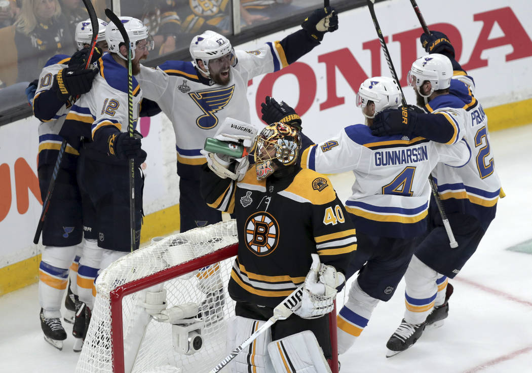 St. Louis Blues' Zach Sanford (12) celebrates his goal with teammates behind Boston Bruins goal ...
