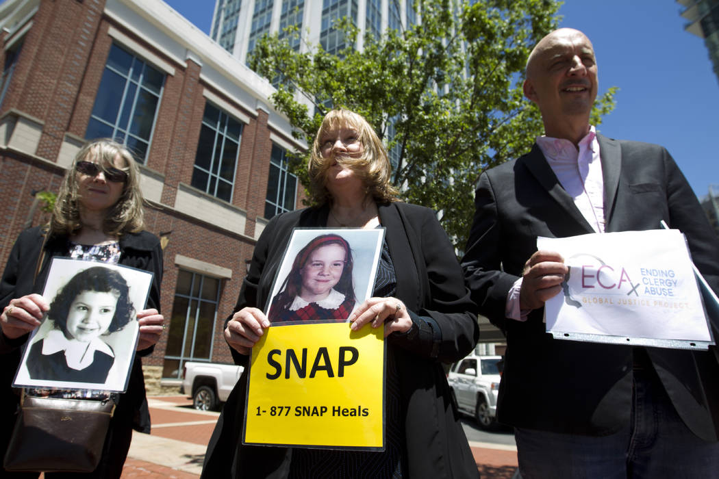 Becky Ianni, center, a victim of priest abuse, holds a picture of her younger self along with o ...