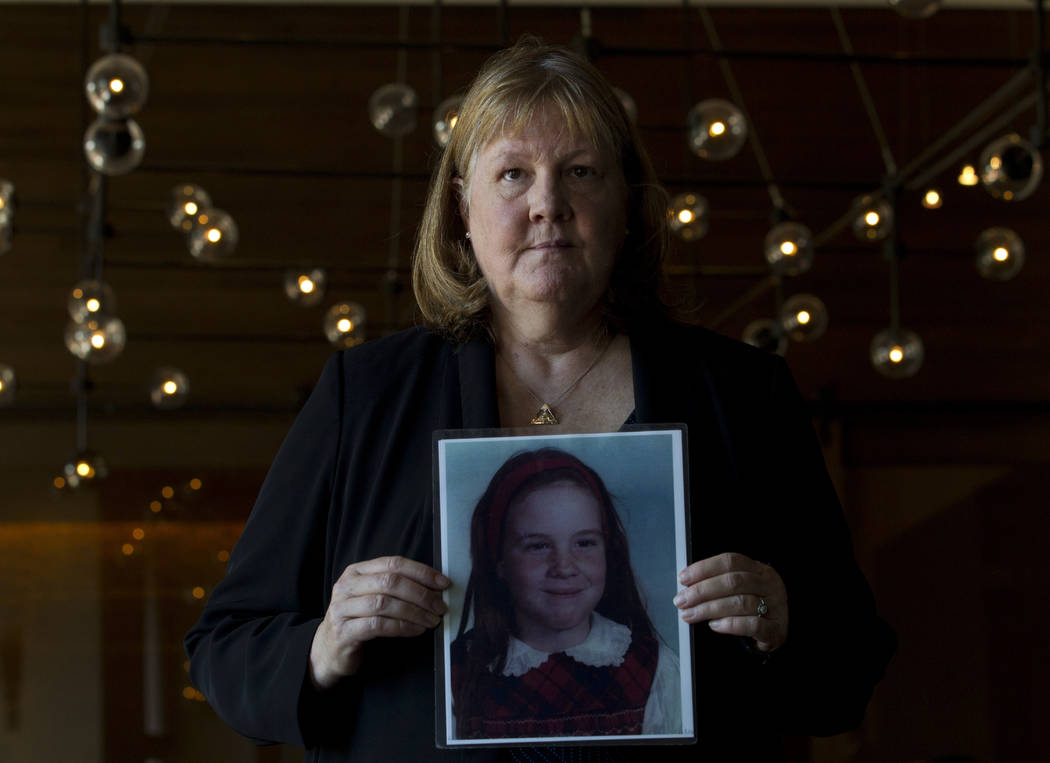 Becky Ianni, a victim of priest abuse, poses for a portrait with a picture of her younger self, ...