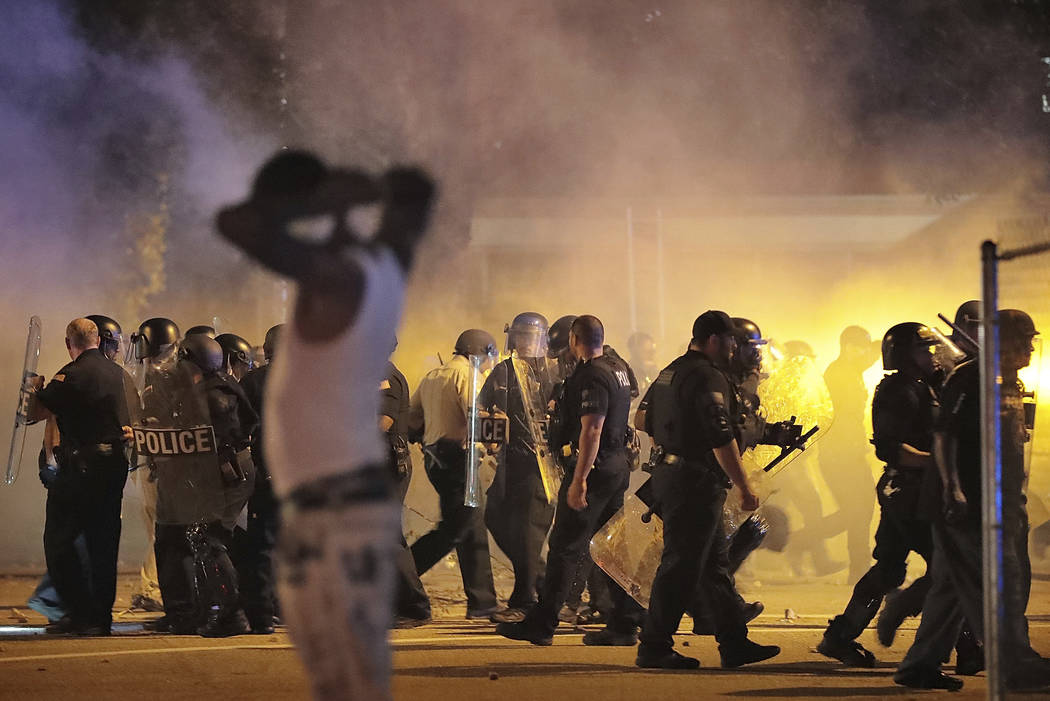 Police retreat under a cloud of tear gas as protesters disperse from the scene of a standoff af ...