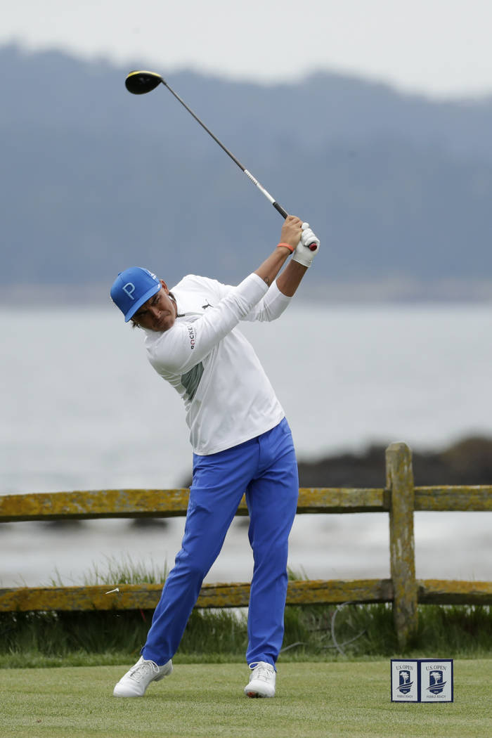 Rickie Fowler watches his tee shot on the 18th hole during the first round of the U.S. Open Cha ...