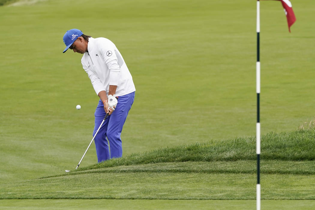 Rickie Fowler hits a chip shot on the ninth hole during the first round of the U.S. Open Champi ...