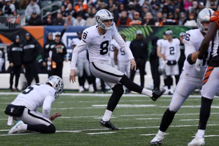 Oakland Raiders kicker Daniel Carlson (8) kicks a field goal with punter Johnny Townsend (5) ho ...