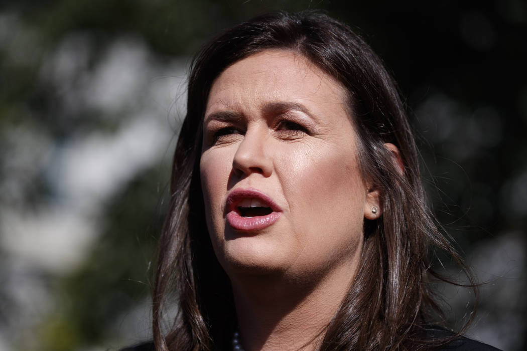 White House press secretary Sarah Sanders talks with reporters outside the White House in Washi ...