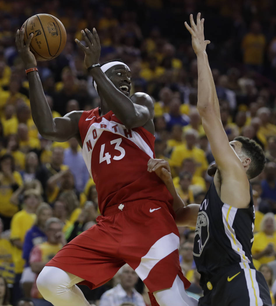 Toronto Raptors' Pascal Siakam, left, looks to pass away from Golden State Warriors' Klay Thomp ...