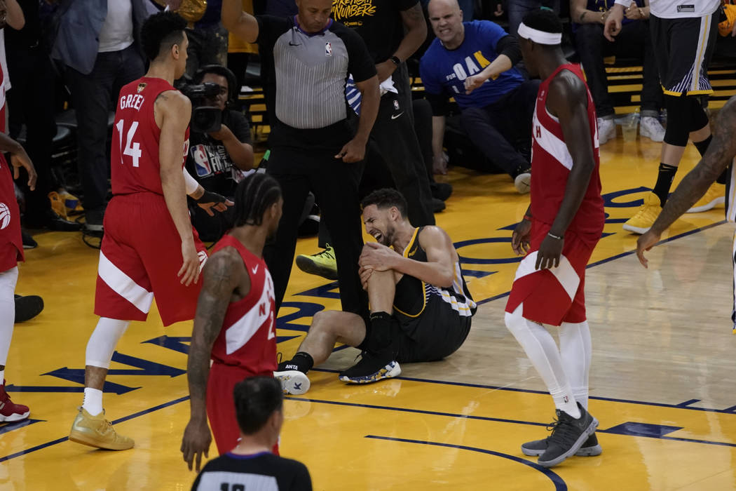 Golden State Warriors guard Klay Thompson, center, reacts after being injured during the second ...