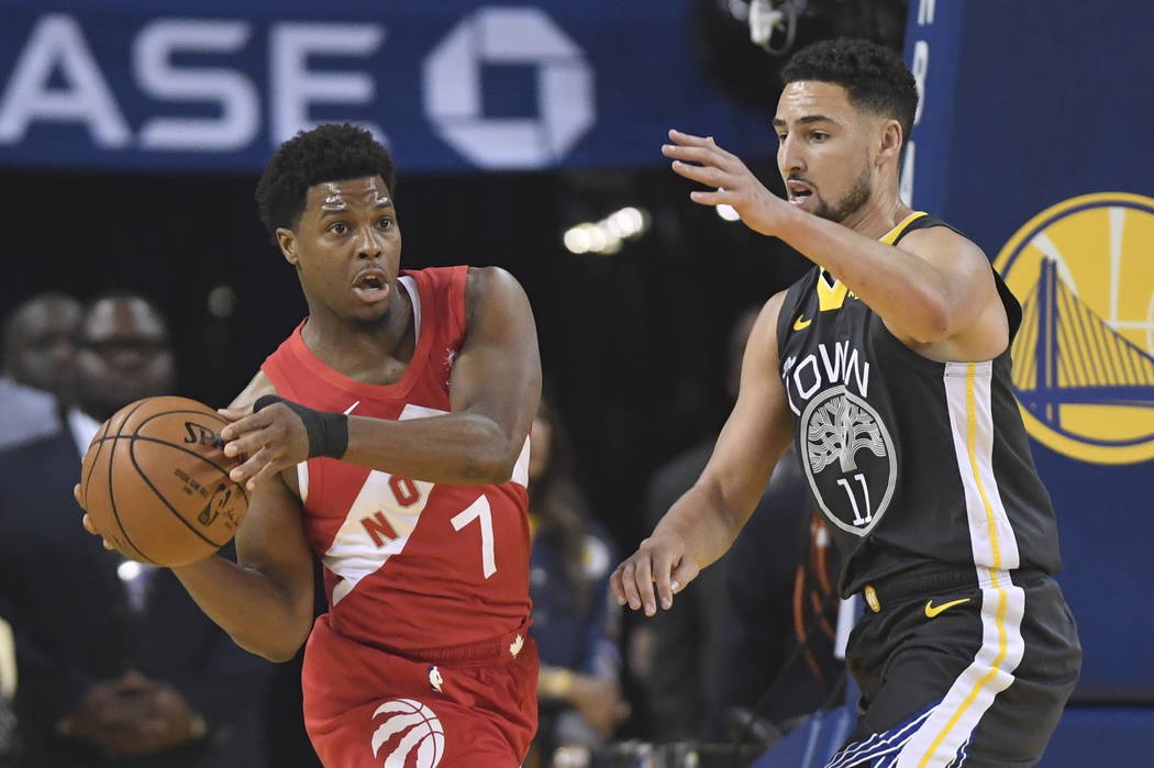 Toronto Raptors guard Kyle Lowry (7) passes the ball in front of Golden State Warriors guard Kl ...