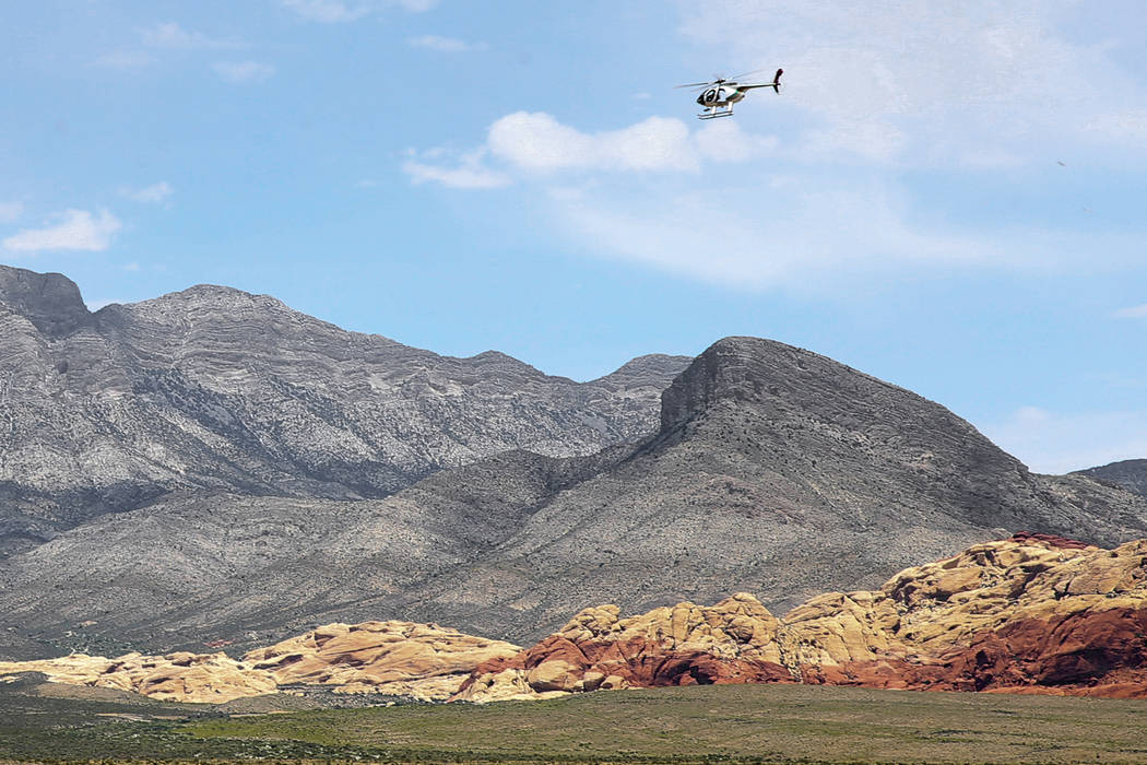 A helicopter flies near the Red Rock Overlook on U.S. Highway 159 in Red Rock Canyon National C ...