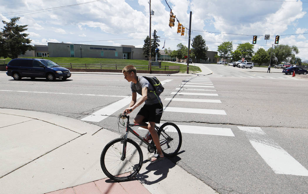 A bicyclist rides away from Columbine High School, Thursday, June 13, 2019, in Littleton, Colo. ...