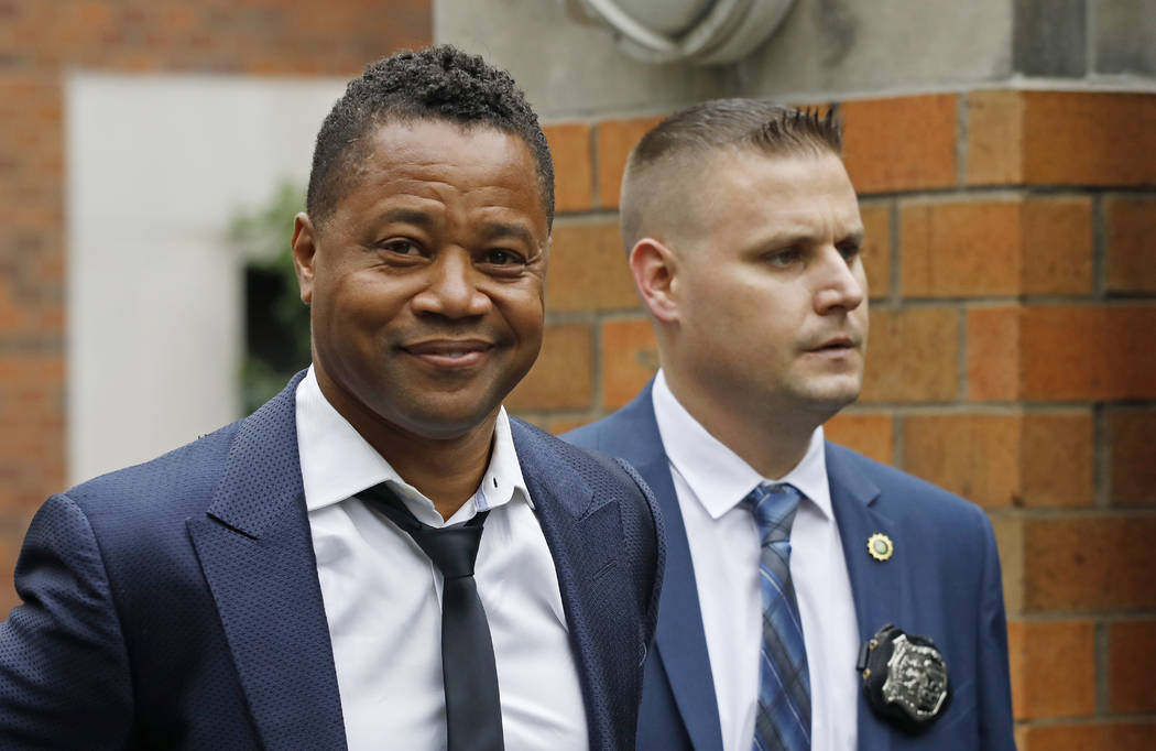 Actor Cuba Gooding Jr., left, is lead by a police officer from New York's Special Victim's Unit ...