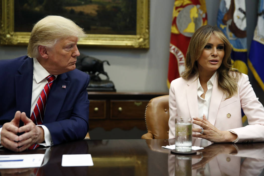 President Donald Trump listens as first lady Melania Trump speaks during a briefing on efforts ...