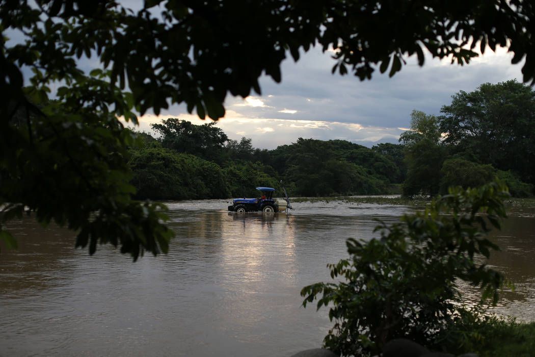 A man drives a tractor through the Suchiate river from Frontera Hidalgo, Mexico, toward Guatema ...