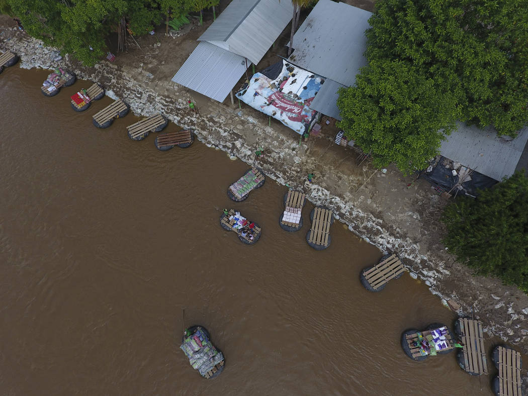 Inner tube and plank rafts ferry passengers and merchandise freely across the Suchiate River be ...