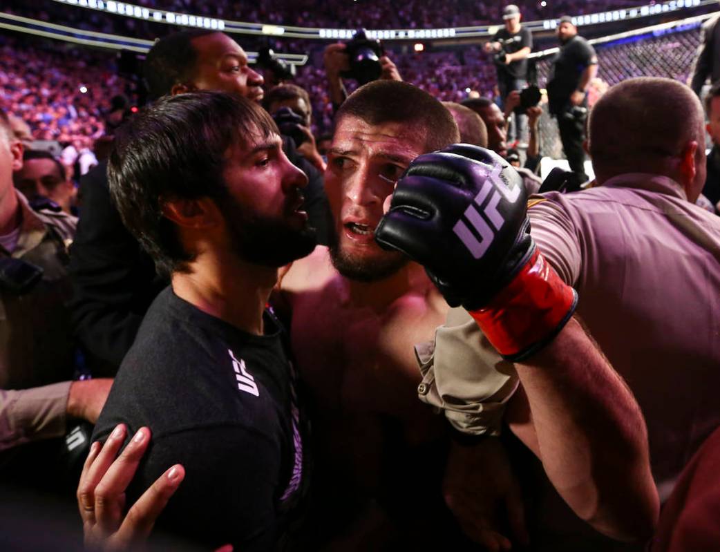 Khabib Nurmagomedov is restrained outside of the octagon after he defeated Conor McGregor at UF ...