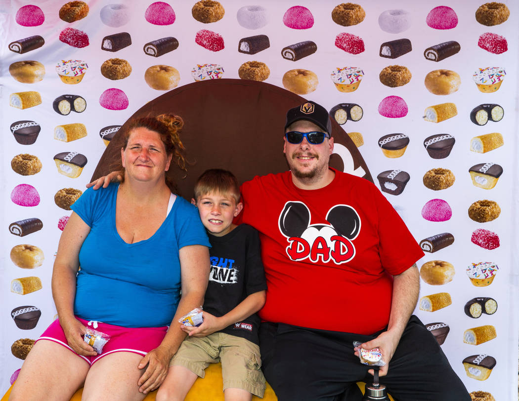 Mary Pfeiffer and son Tristan, 9, join Chris Orando in a photo atop a giant Twinkie while on a ...