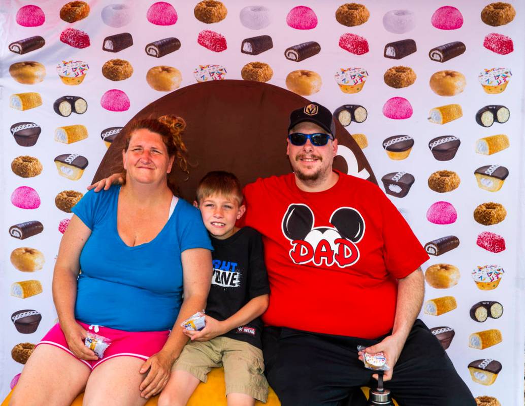 Mary Pfeiffer and son Tristan, 9, join Chris Orando in a photo atop a giant Twinkie while on a ...