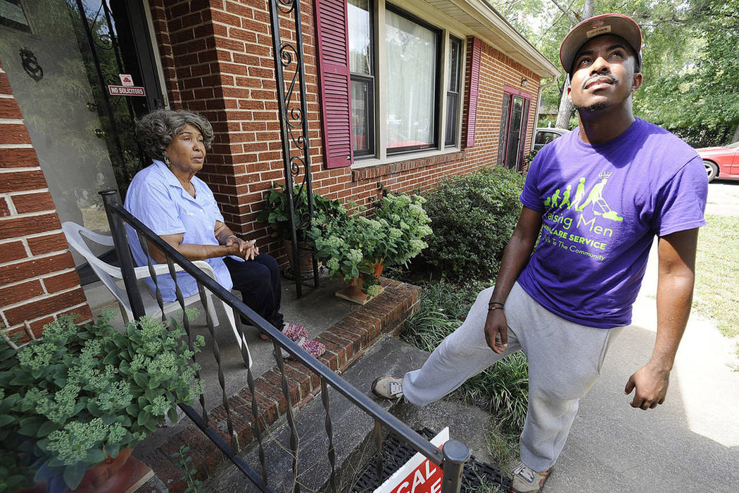 Rodney Smith Jr., founder of Raising Men Lawn Care Service, looks skyward while talking with ho ...