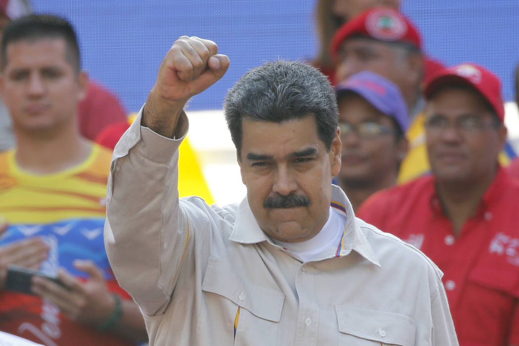 FILE - In this April 6, 2019 file photo, Venezuela's President Nicolas Maduro raises his fist t ...