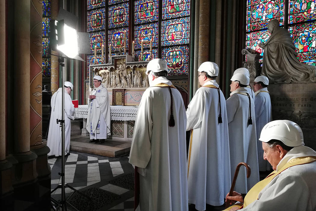 The Archbishop of Paris Michel Aupetit, second left, leads the first mass in a side chapel, two ...