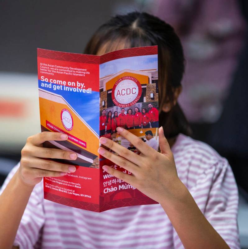 Attendee Irene Cho reads an Asian Community Development Council pamphlet during a seminar on ho ...