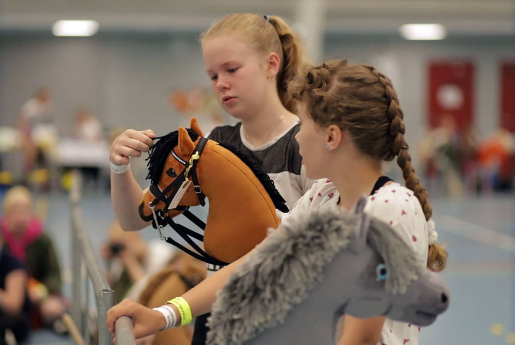 Young hobby horse competitors care for their toy horses in Seinajoki, Finland, on Saturday, Jun ...