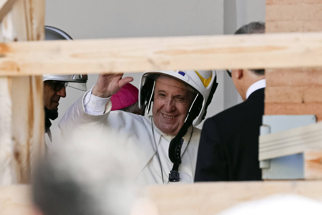 Pope Francis wears a safety helmet as he arrives to visit the earthquake damaged Cathedral of C ...