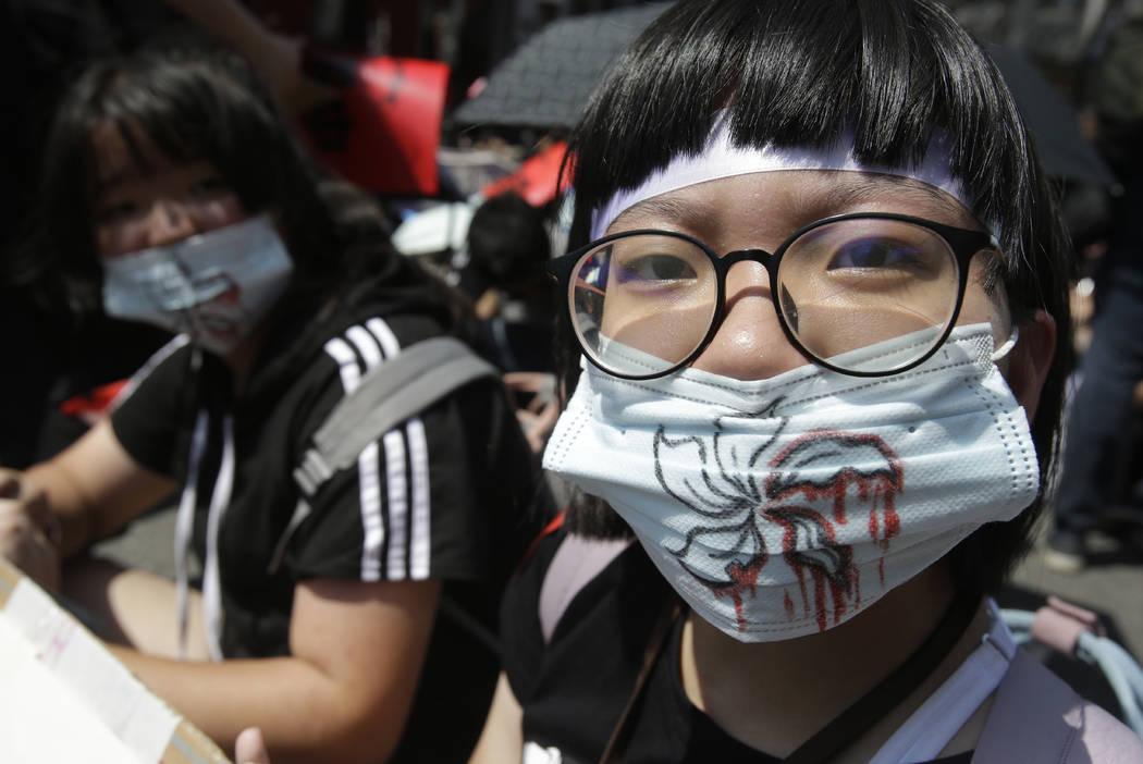 Supporters wear masks with bloody flowers painting for mourning to proposed extradition bill ou ...